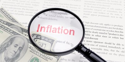 Inflation word in newspaper. Red text and US dollar banknotes under a magnifier. Global Economic crisis concept. 3d render
