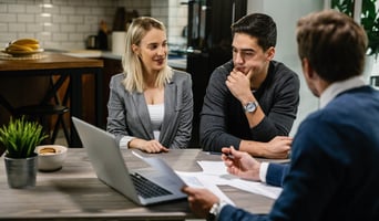 Young couple talking to insurance agent and reviewing coverage