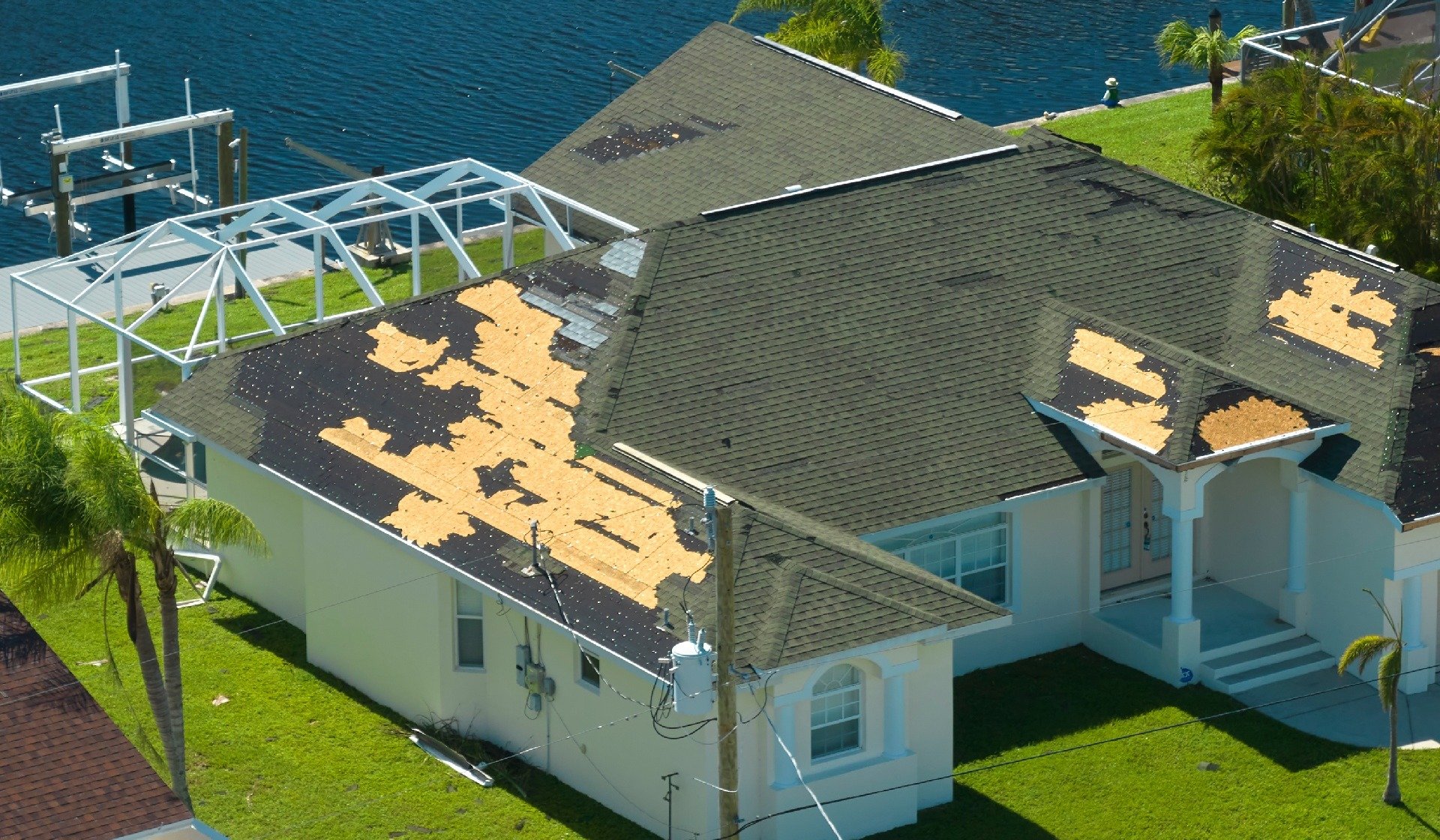 Damaged house roof with missing shingles after hurricane Ian in Florida. Consequences of natural disaster