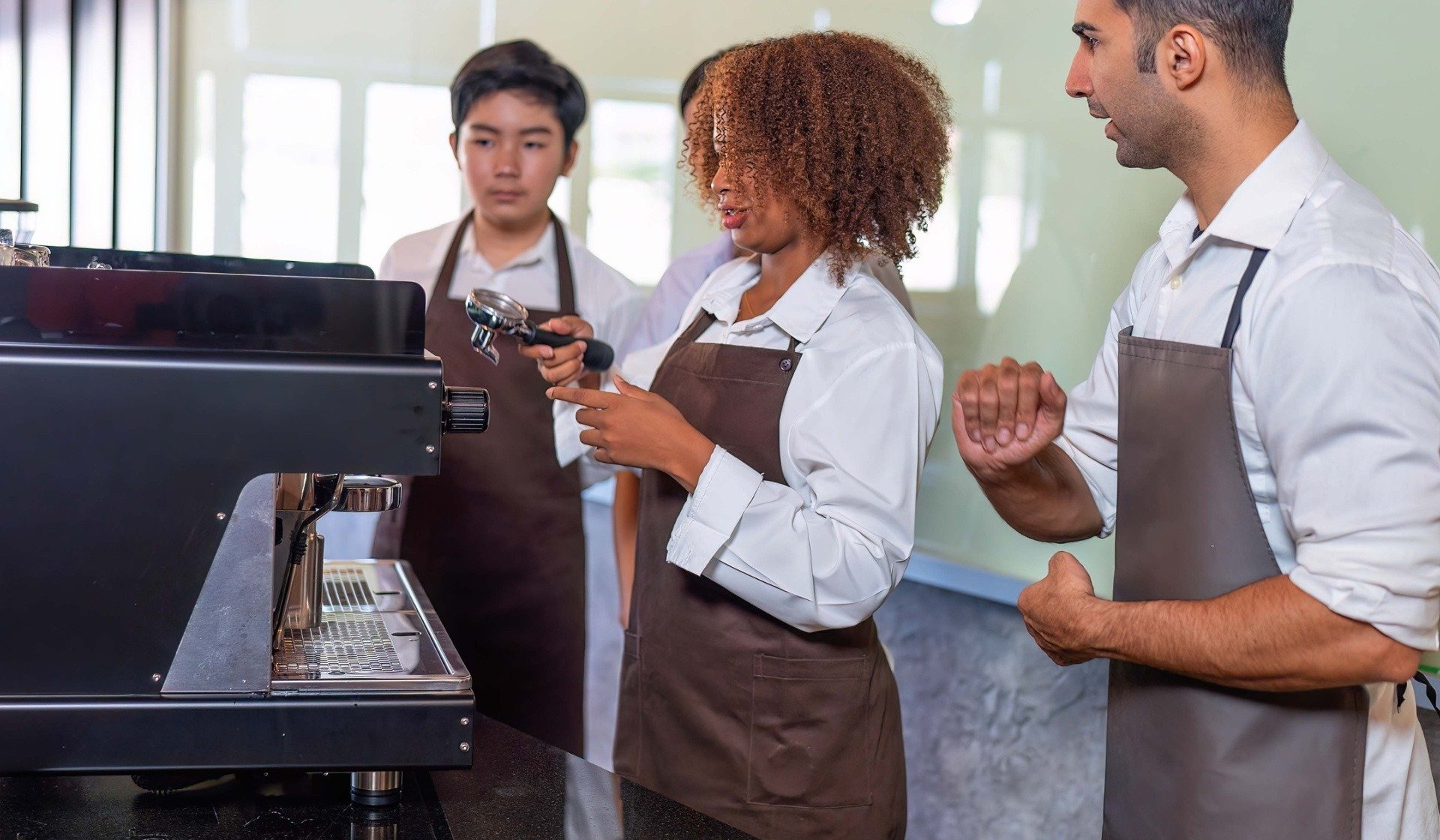 Training young employee to use expresso machine correctly