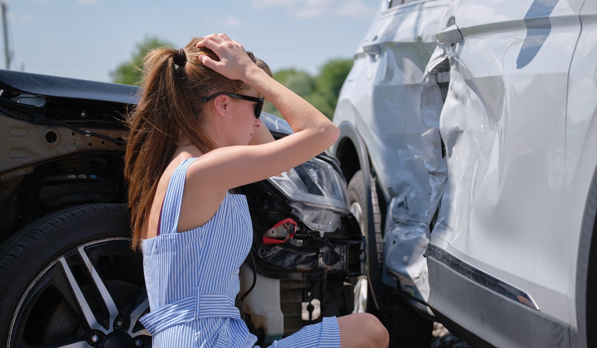 Woman looking at damage to vehicles after collision 